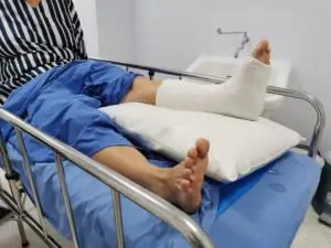 person laying in a hospital bed with a leg cast