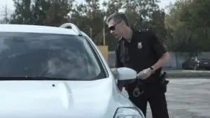 A police officer questioning a driver in a white SUV