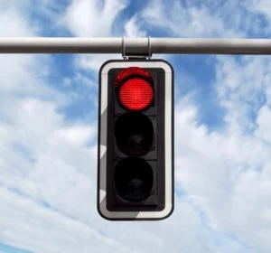 red traffic light against a blue sky