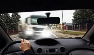 A white truck about to collide with a car.