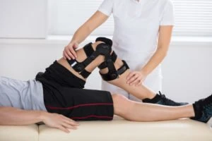 A physical therapist helps a patient with an injured knee