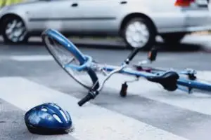 helmet and bike lying on the road after an accident with a car