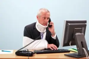 injured man tries to multitask at work