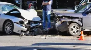 man surveys damage of a head-on collision