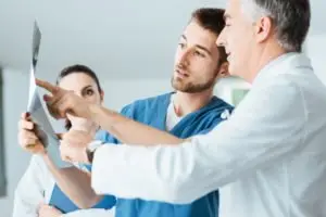 medical professionals confer over an x-ray