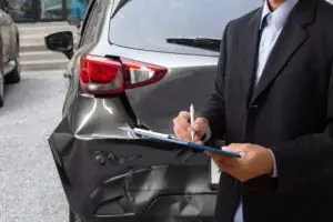insurance adjuster reviews vehicle damage