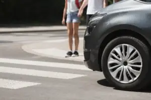 pedestrians wait to cross the street