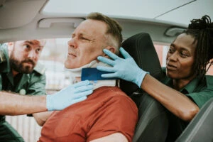 paramedics assist a man with a neck injury 