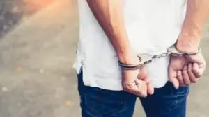 man in white shirt in handcuffs