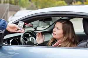 woman talking to a cop holding a breathalyzer test