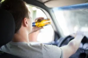 young man drinking behind the wheel