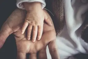 Baby hand on top of an adults hand.