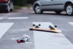 Skateboard and a shoe lying on road after a pedestrian accident