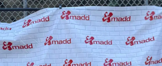 MADD banner on fence