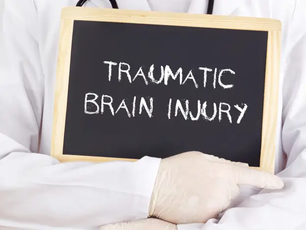 doctor-holding-a-chalkboard-that-reads-traumatic-brain-injury