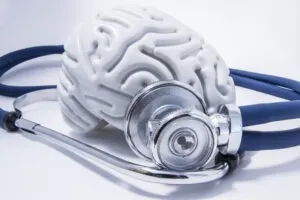 A stethoscope is placed near a figure of the human brain, insinuating traumatic brain injury. Call a West Sacramento lawyer now.