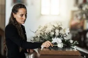 sad-woman-with-flowers-on-coffin