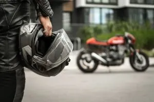 biker-walking-holding-motorcycle-helmet