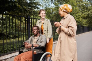 friends walking with black man in wheelchair