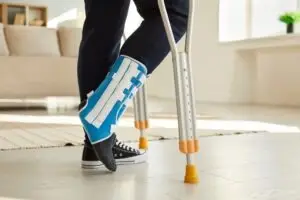 person in foot cast with cane