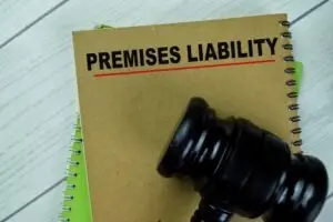 An overhead view of a gavel on top of a notebook that says “premises liability” on it.