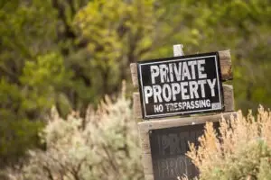 The photo shows a private property sign. What should I do immediately after an accident on someone else’s property?