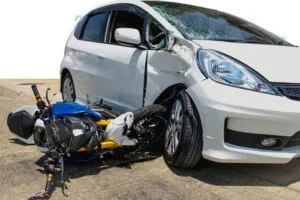 A car and motorcycle after a crash. We can explain how liability is determined in motorcycle accident cases.