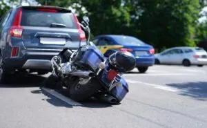 A motorcycle and car after a collision. A lawyer can explain how long it takes to settle a motorcycle accident case.