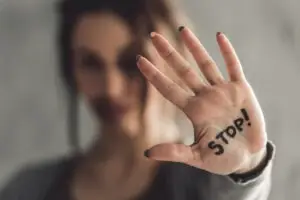 out-of-focus-young-woman-with-stop-written-on-her-palm