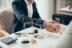 Two Business Men Shaking Hands Over A Desk