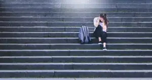 young-woman-sitting-alone-on-college-steps
