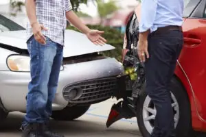 two-people-discuss-their-accident-in-front-of-their-cars