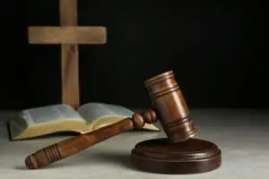 gavel-bible-cross-on-dark-lit-table-in-clergy-sex-abuse-case