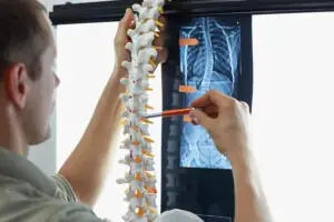 doctor-comparing-spinal-xray-and-replica-Okemos