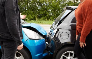 Two drivers arguing with a fender bender in the background.