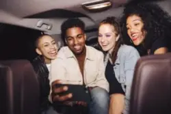 group taking selfie in the back of a rideshare car