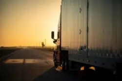truck driving down the road at sunset