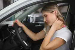 blonde woman struggling with whiplash after a car crash