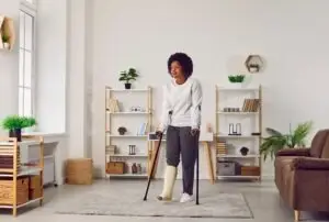 black woman on crutches in her living room