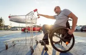 man in a wheelchair pushing a shopping cart
