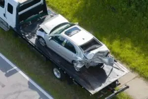overhead view of tow truck carrying car after truck crash