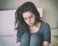 sad woman sitting on a bed
