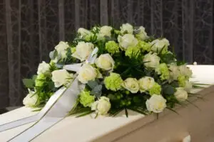white roses on a casket at a funeral