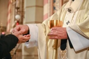 priest giving parishioner sacramental bread