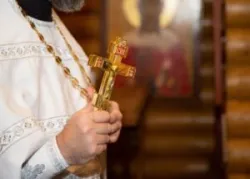 priest holding a cross