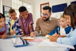 teacher sitting with his class