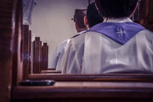 Priests sitting in a church pew. Father Thomas Anderson sexual abuse accusations