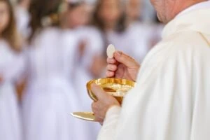 A priest giving communion. Father Emil Beyer sexual abuse accusations.