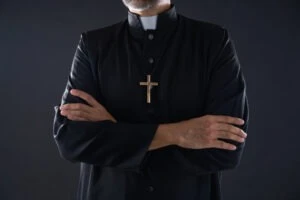 A priest with their arms crossed. What is the Christian Reformed Church’s history of abuse?