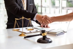 A lawyer and a client shaking hands after discussing an abuse case that took place years ago.